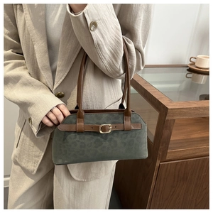 Detail of leopard print suede handbag with leather handle and gold buckle decoration