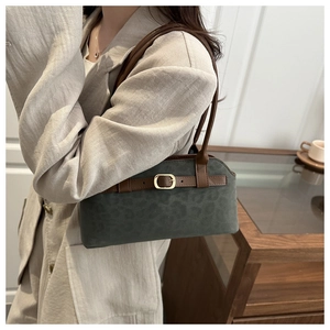 Detail of dark green suede underarm bag with subtle leopard print and gold buckle