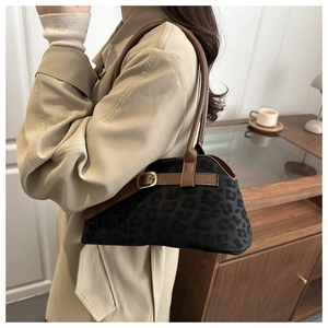 Close-up of leopard print shoulder bag with brown leather strap in a vintage interior
