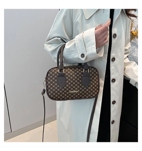 Détail d'un sac à main vintage à motif géométrique avec poignées en cuir et dorures
