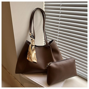 Detail of dark brown leather tote bag with interior pouch and decorative silk scarf