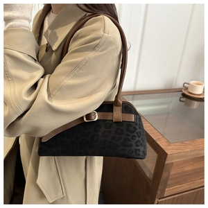 Detail of vintage leopard print shoulder bag with brown leather strap and gold buckle accent