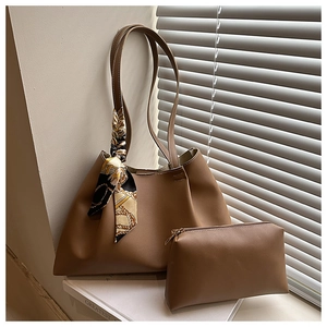 Detail view of brown leather tote and inner pouch set with decorative silk scarf