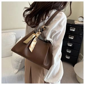 Deep brown leather tote bag with a decorative floral silk scarf on the shoulder strap