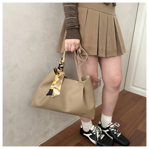 Detail of khaki tote bag with a vintage patterned silk scarf on the side handle