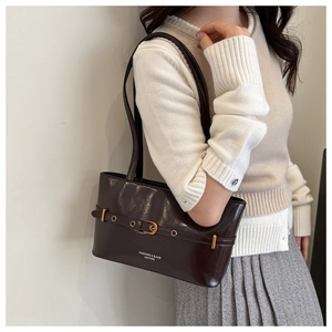 Détail du sac à bandoulière en similicuir marron foncé avec boucle vintage et logo