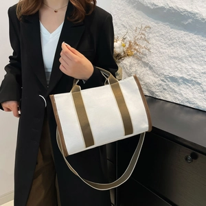Large olive green and white canvas tote bag with brown leather trim and shoulder strap