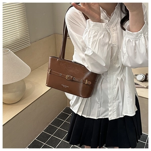 Detail view of brown oil wax leather shoulder bag with vintage metal buckle decoration