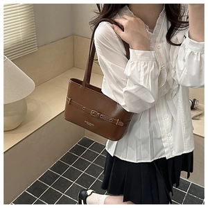 Détail du sac hobo en cuir marron avec boucle vintage et fine bandoulière d'épaule