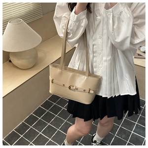 Détail du sac cabas vintage crème avec boucle de ceinture et texture en cuir mat élégant