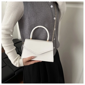 Detail of white mini square bag with glossy PU leather and elegant gold chain strap