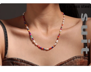 Détail d'un collier en acier inoxydable avec perles colorées et perles d'eau douce sur mannequin