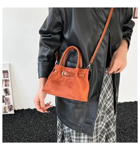 Caramel faux suede bucket bag with leather strap shown in a vintage street style shoot