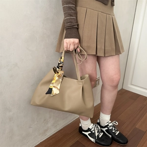Large khaki leather tote bag with a decorative floral silk scarf on the handle