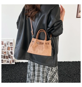 Brown frosted bucket bag with belt detail worn by a model in a minimalist setting