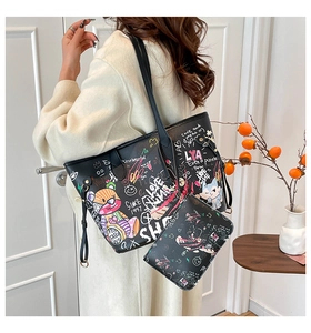 Detailed view of black graffiti crossbody camera bag with wide shoulder strap