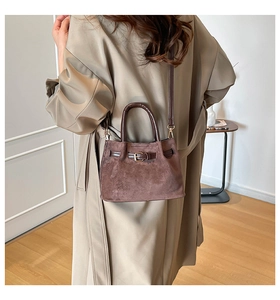 Detail of vintage brown faux suede bucket bag showing texture and leather strap