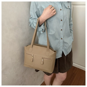 Detail of khaki tote bag with dual symmetrical zipper pockets and long shoulder straps