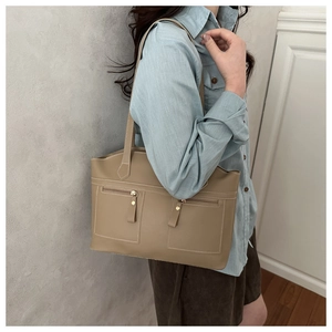 Detail of khaki leather tote bag showing side view and dual zipper pocket design
