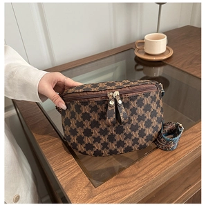 Detail view of vintage brown monogram sling bag with gold zippers and woven strap