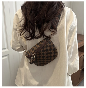 Detail of vintage crossbody crescent bag featuring M-pattern and retro woven strap
