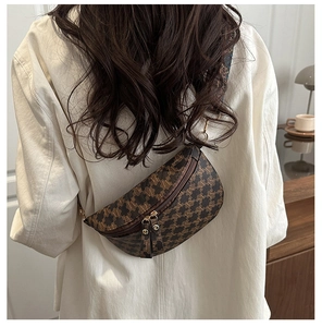 Detail of vintage crescent bag showing brown M-pattern texture and colorful woven strap