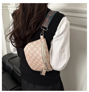 Close-up of beige moon-shaped chest bag with M pattern and colorful ethnic strap