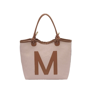 Large hand-woven tote bag in pale pink with brown leather M patch and knotted handles