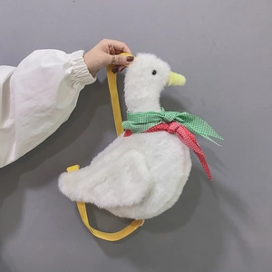 Detail of cute white plush duck bag featuring a decorative scarf and yellow strap