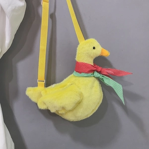 Detail of yellow plush duck bag featuring a red polka dot scarf and adjustable strap