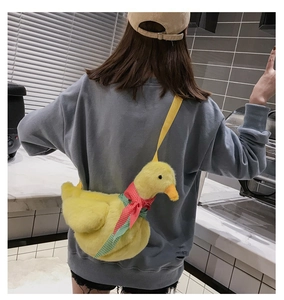 Detail of cute yellow plush duck crossbody bag with colorful ribbon and soft texture