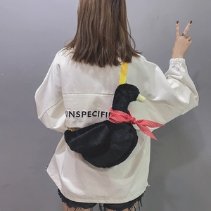 Detail of creative black plush duck crossbody bag with polka dot scarf and yellow strap