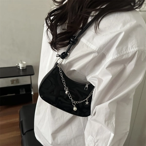 Chic black crescent underarm bag with silver star and pearl chain on white shirt