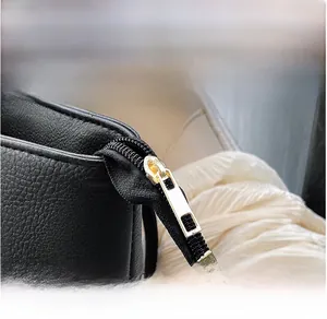 Macro detail of high-quality golden zipper on black lychee grain leather tote bag