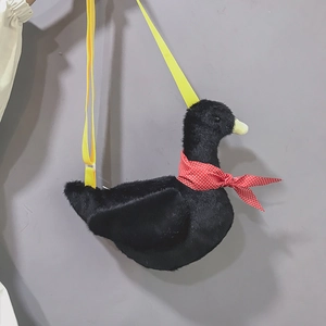 Detail of creative black swan plush bag with yellow strap and red polka dot scarf