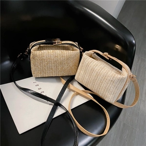 Detail of woven straw shoulder bags with metal clasp and V-shape pattern textures