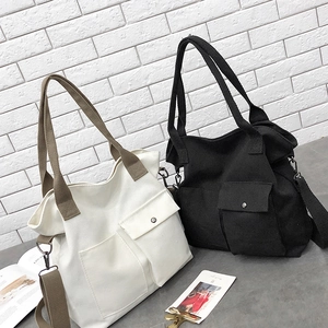 Detail of large canvas tote bag with adjustable strap and functional front pockets