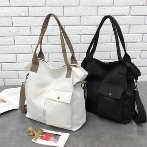 Minimalist canvas tote bags in white and black with dual pockets and adjustable straps