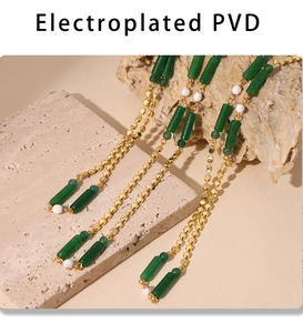 Dettaglio catena placcata in oro PVD con pietre verdi e perle bianche decorative