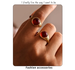 Detail of vintage PVD gold plated rings with large garnet red cabochon stones on fingers