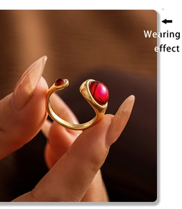 Macro shot of an adjustable gold ring featuring two elegant dark red garnet cabochons