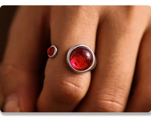 Macro shot of an adjustable stainless steel open ring featuring two round red garnets