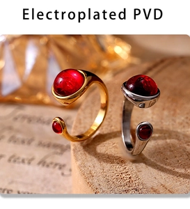 Macro shot of PVD gold and silver rings with red stones on a vintage wooden tray