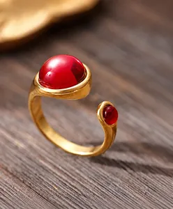 Close-up of gold-plated stainless steel open ring with two red garnet style stones