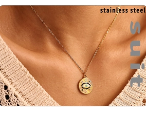 Gros plan d'un collier en acier doré avec pendentif œil bleu porté par un mannequin