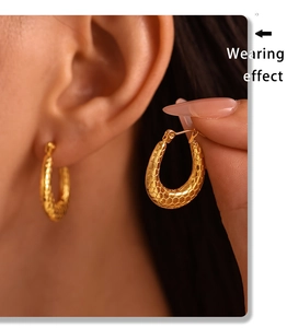 Wearing effect showing 18K gold plated hoop earrings with scale texture on the ear