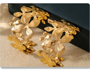 Macro shot of gold-plated 18K flower bangles with layered petals on a leather jewelry box
