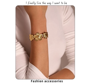 Detailed macro view of PVD gold plated floral bracelet on wrist with radiant textures