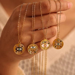 Coffret de quatre colliers avec pendentifs œil maléfique doré tenu par une main élégante