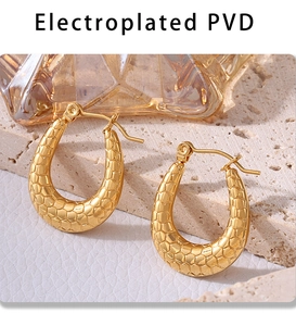 Detailed macro view of 18K gold-plated U-shaped earrings with textured horseshoe pattern